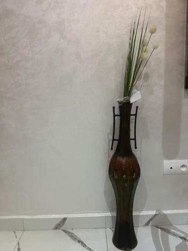 a vase with flowers in it on a wall at Magnificent Cozy New Luxury Condo in Prime Casablanca Location in Les Camps