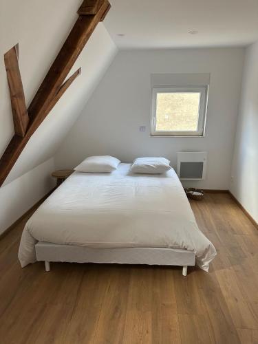une chambre avec un lit blanc dans un grenier dans l'établissement Maison dans un havre de paix, à Hartmannswiller