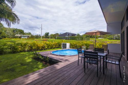 a deck with a table and chairs and a swimming pool at Casa para Vacacionar Increible en Bejuco in Loma