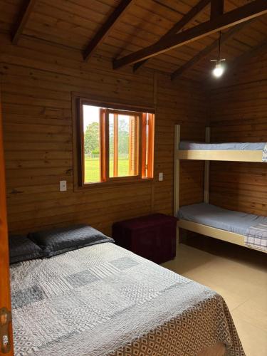a bedroom with two bunk beds and a window at Morada da Lagoa in Garopaba