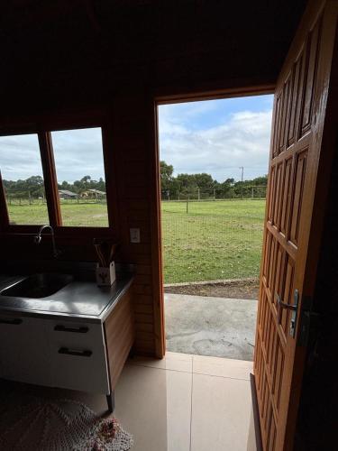 a bathroom with a sink and a view of a field at Morada da Lagoa in Garopaba