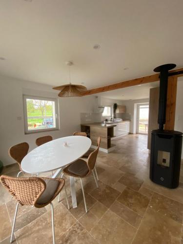 une cuisine avec une table, des chaises et une cuisinière dans l'établissement Maison dans un havre de paix, à Hartmannswiller