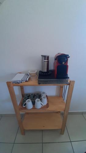 a shelf with cups and a coffee maker on it at Chez nous ! in Cilaos