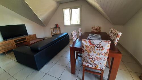 a living room with a couch and a table and a television at Chez nous ! in Cilaos
