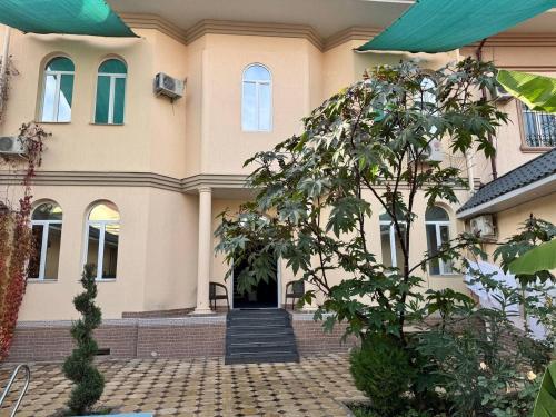 a large house with a staircase in front of it at Rahat inn Hotel in Tashkent