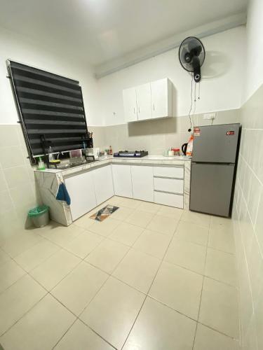 eine Küche mit weißen Schränken und einem Kühlschrank in der Unterkunft Syakif Homestay HICOM University in Pekan