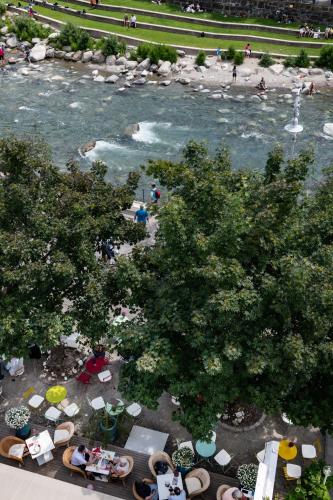 an aerial view of a river with people sitting around tables at Hotel Aurora in Merano