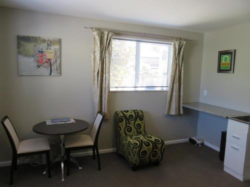 a small room with a table and chairs and a window at McWilliam Apartments in Christchurch