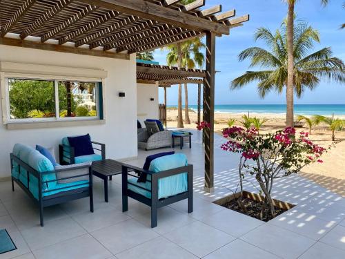 a patio with chairs and a table on the beach at Vila Mare - Praia de Chaves frontline in Cabeçadas