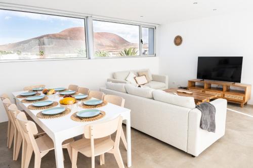 a living room with a white table and a white couch at Almara House - Luxury Villa with Heated Pool in La Oliva