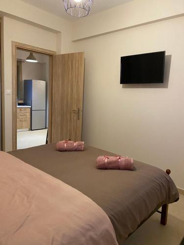 a bedroom with a bed with two pink pillows on it at Villa Marialena III in Kato Gatzea