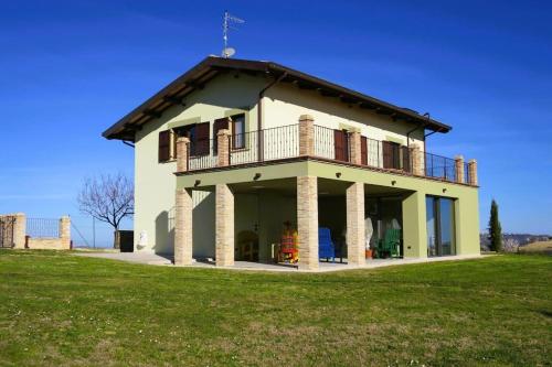 a house with a balcony on top of a field at Characteristic restored farmhouse with 360 degree views in Montefino