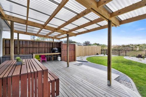 a wooden pergola with a table on a deck at Beachfront Holiday Home Close to Airport in Lauderdale