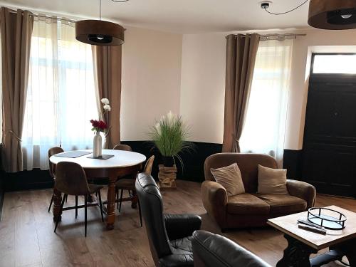 un salon avec une table et des chaises dans l'établissement L'Estaminet Meublé de Tourisme Classé 2 étoiles, à Origny-Sainte-Benoîte