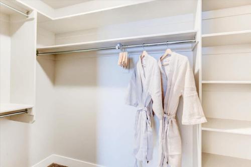 a closet with white clothes hanging on a rack at Golf Course Close By Minutes from UVU BYU in Orem
