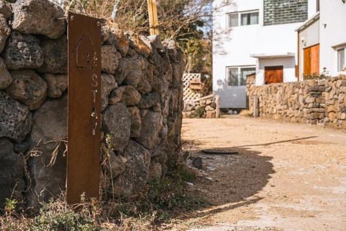 una señal frente a una pared de piedra en Jeju Stay Orot, en Jeju