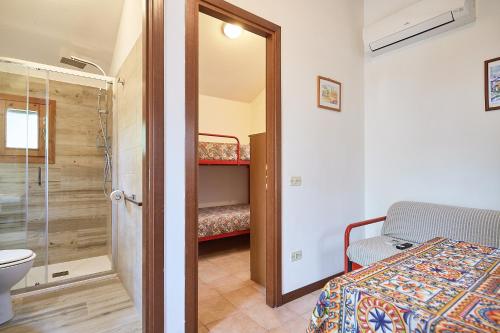 a bathroom with a shower and a bed and a toilet at Caravelle Camping Village in Ceriale