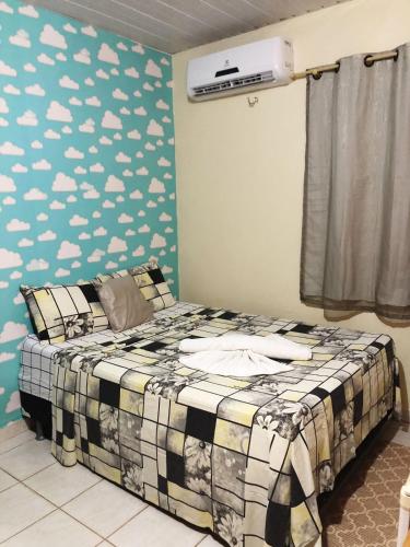 a bedroom with a bed with clouds painted on the wall at Pousada Arara in Santarém