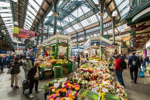 des gens qui déambulent sur un marché de fruits et légumes dans l'établissement Fabulous Leeds City Center Urban Loft, à Leeds