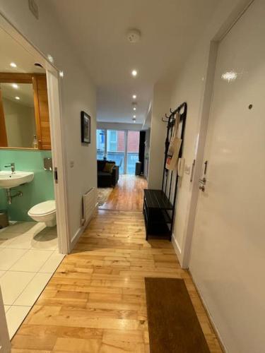 a hallway of a bathroom with a toilet and a sink at Fabulous Leeds City Center Urban Loft in Leeds
