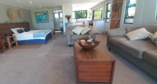 a living room with a couch and a bed at Island Lake Villa and Bungalow in Wilderness