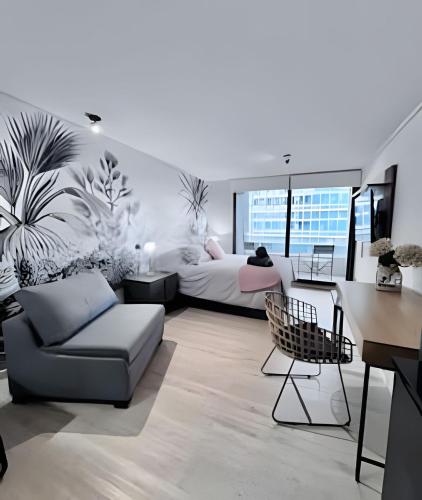 a living room with a bed and a couch at Estudio chic al costado CLC in Santiago