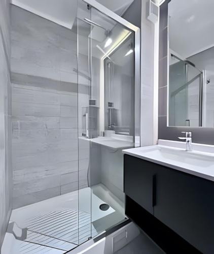 a bathroom with two sinks and a glass shower at Estudio chic al costado CLC in Santiago
