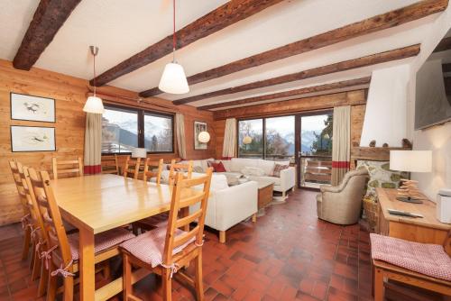 a dining room with a table and a couch at Chalet Taipan Verbier in Verbier
