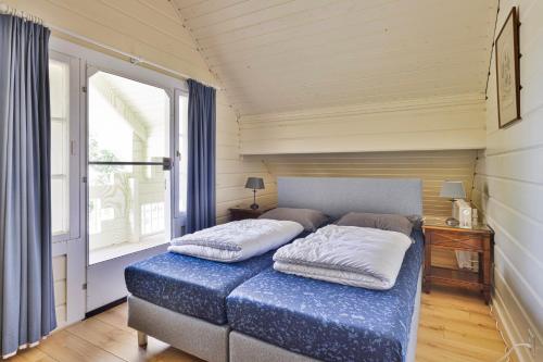 a bedroom with a bed with two pillows on it at Vakantiehuis De Hut in Oostkapelle