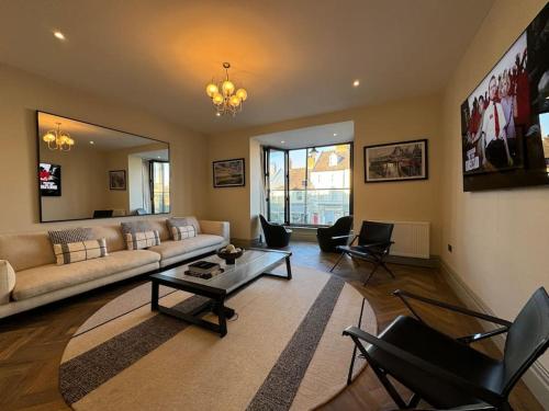 a living room with a couch and a table and chairs at Priory Castle Apartment, Tynemouth in Tynemouth