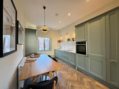 a kitchen with a wooden table and a dining room at Priory Castle Apartment, Tynemouth in Tynemouth
