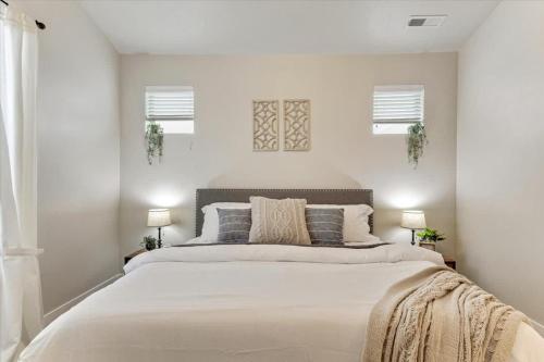 a white bedroom with a large bed with pillows at FrontRunner Lehi Station Fully Equipped Kitchen in Lehi