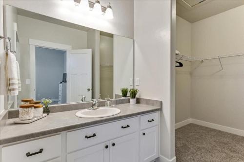 a bathroom with a sink and a large mirror at FrontRunner Lehi Station Fully Equipped Kitchen in Lehi