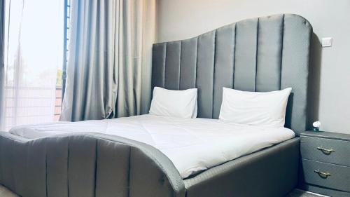 a bed with a large headboard in a bedroom at Modest Apt on the Lake in Kampala