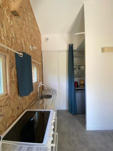 une cuisine avec un évier et un plan de travail dans l'établissement Maisonnette au calme, grand jardin privatif, accueil vélos et motos, à Sancé