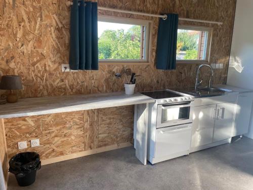 une cuisine avec un comptoir, un évier et une fenêtre dans l'établissement Maisonnette au calme, grand jardin privatif, accueil vélos et motos, à Sancé