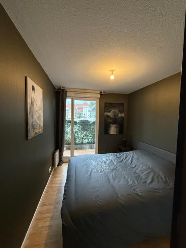 une chambre avec un lit blanc et une fenêtre dans l'établissement Le Coin tranquille, à Colmar