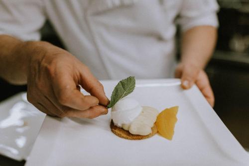 a person eating a dessert on a white plate at Hotel Aurora in Merano