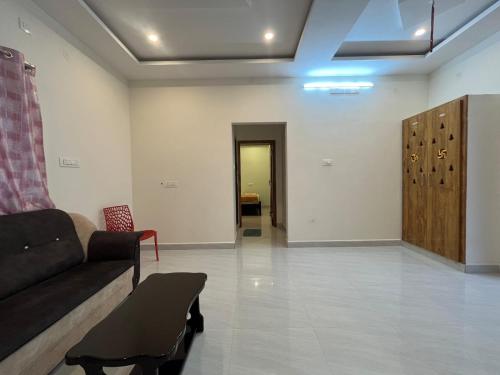 a living room with a couch and a hallway at Padmavathi Homestay -2BHK 1BHK AC Apartments for group of families - Best location - Flyover to Alipiri gate - Walk to PS4 Veg Restaurant - Modular Kitchen - Super fast Wi-Fi- Near to Tirupati Bus Stand 2 KM-Near to Railway Station 2KM in Tirupati