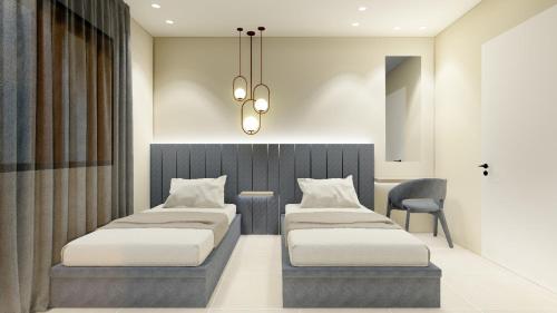 a bedroom with two beds and a chandelier at Tabarja hills in ‘Ayn aş Şughayrah