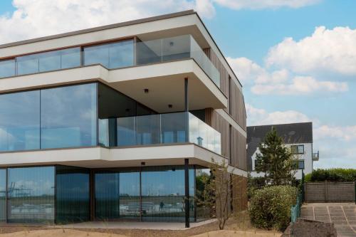 a building with a lot of glass windows at Beach House Terra in Zeebrugge