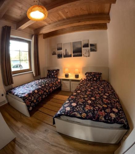 a bedroom with two beds and a window at Domki Smokowo in Gołubie