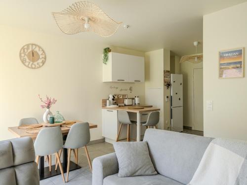 une cuisine et un salon avec un canapé et une table dans l'établissement Appart cosy sunset, à Mimizan-Plage