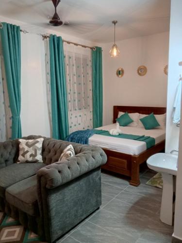 ein Wohnzimmer mit Sofa und Bett in der Unterkunft Pride Studio II in Mombasa