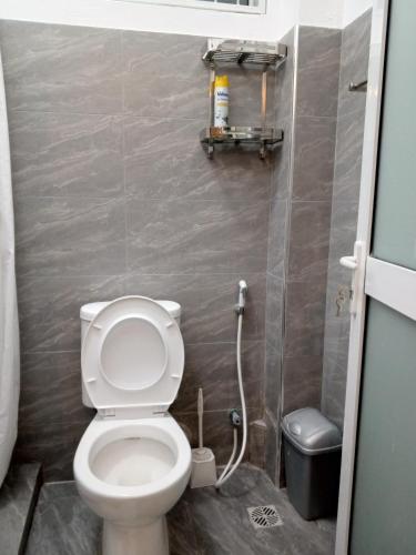 ein kleines Badezimmer mit Toilette und Mülleimer in der Unterkunft Pride Studio II in Mombasa