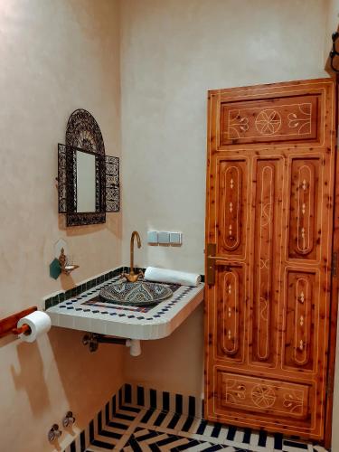 a bathroom with a sink and a large wooden cabinet at Imsouane WOOD HOUSE in Imsouane