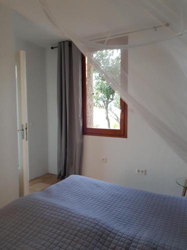 une chambre blanche avec un lit et une fenêtre dans l'établissement Appartement VUE MER an der Côte d'Azur für 2-3 Personen mit Gartenanteil, à Vence