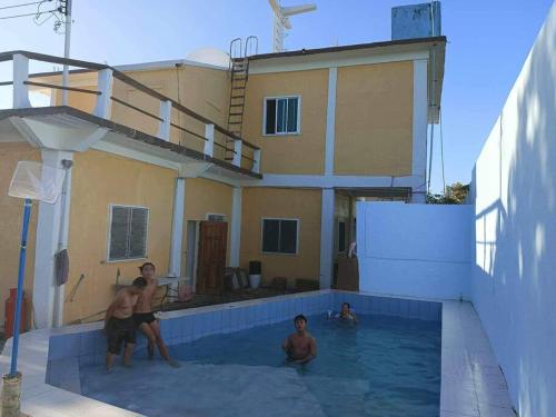 a group of people in a swimming pool next to a house at Huge house with seaview in Daanbantayan