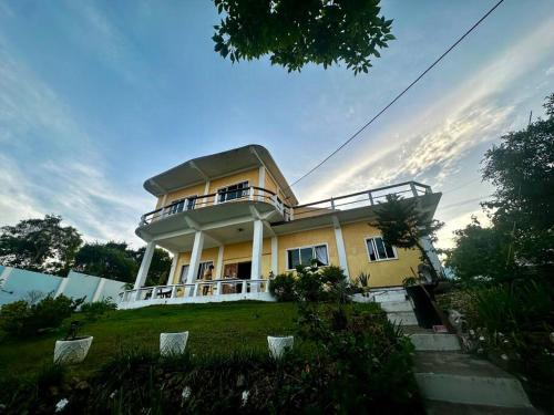 a large yellow house on top of a hill at Huge house with seaview in Daanbantayan