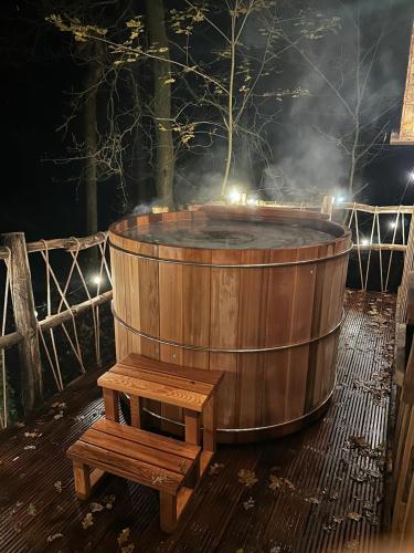 a wooden hot tub with a wooden bench in front at New Unique Treehouses with hot tub in Oisterwijk in Oisterwijk